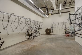 A room with a white wall and a bicycle hanging on the wall.